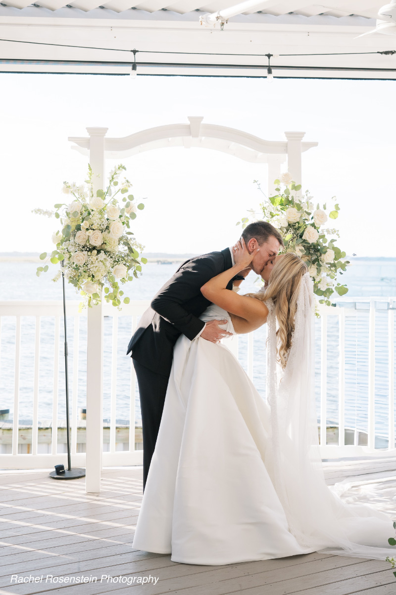 Bride-groom-kiss-under-floral-wedding-arch-WEDDING-&-EVENTS-Ceremonies-Avalon-Yacht-Club